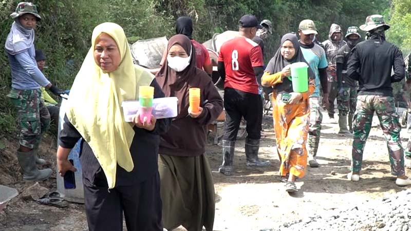 Serbuan "manis” dari ibu-ibu Desa Tonala yang datang membawa logistik berupa kue tradisional, gorengan, kopi hangat untuk Satgas TMMD. (foto.penrem)